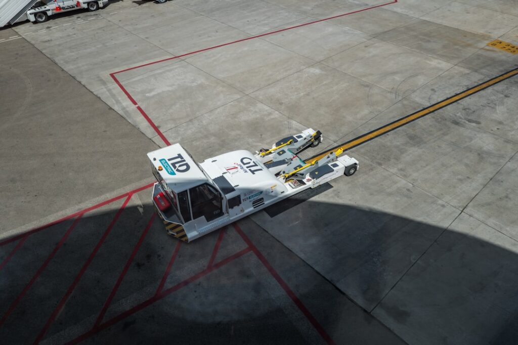 A busy airport scene with ground support vehicles and personnel assisting aircraft, showcasing the operational aspects of Fixed Base Operators (FBOs).