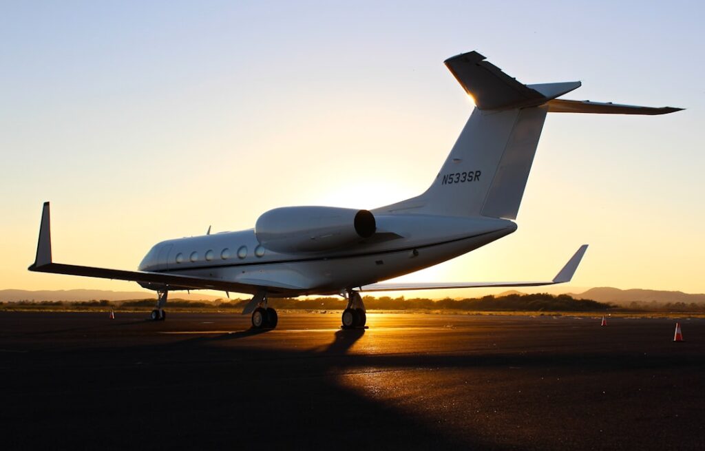 A sleek private jet on a runway with a clear blue sky, symbolizing luxury travel and aviation choices.